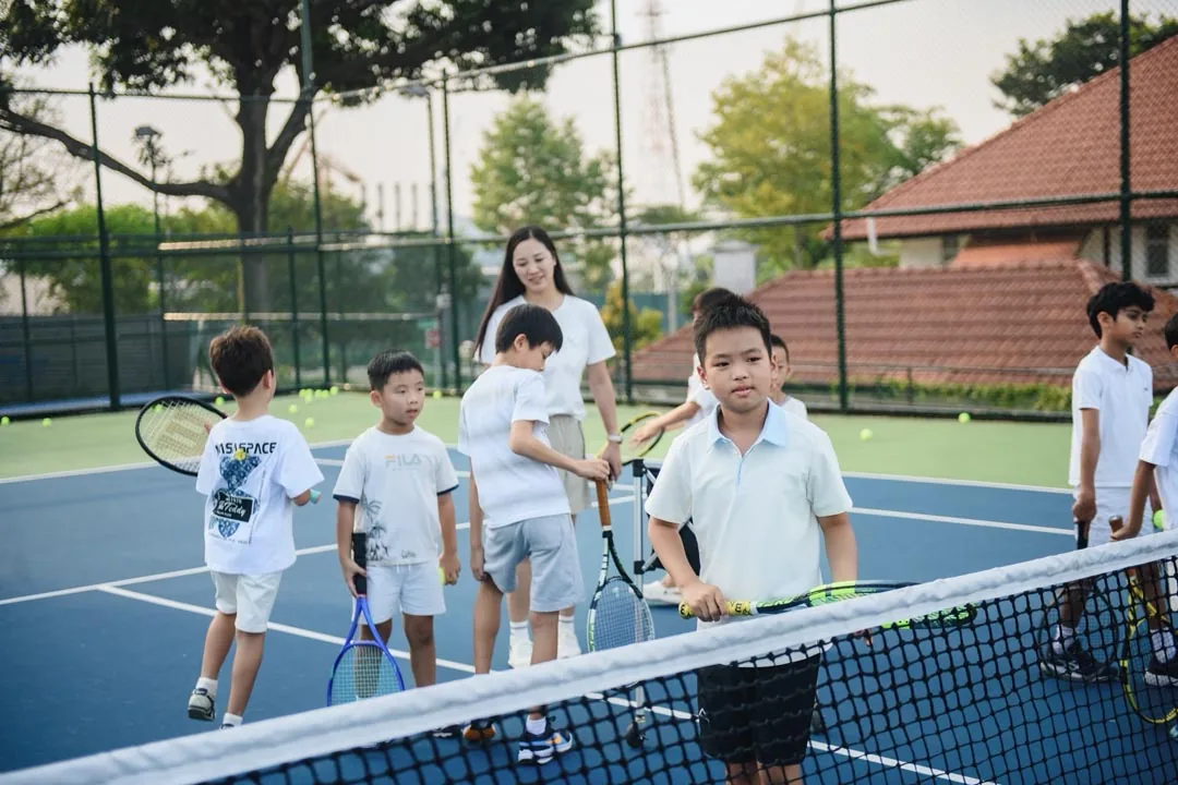 Juniors at the net with their racquets