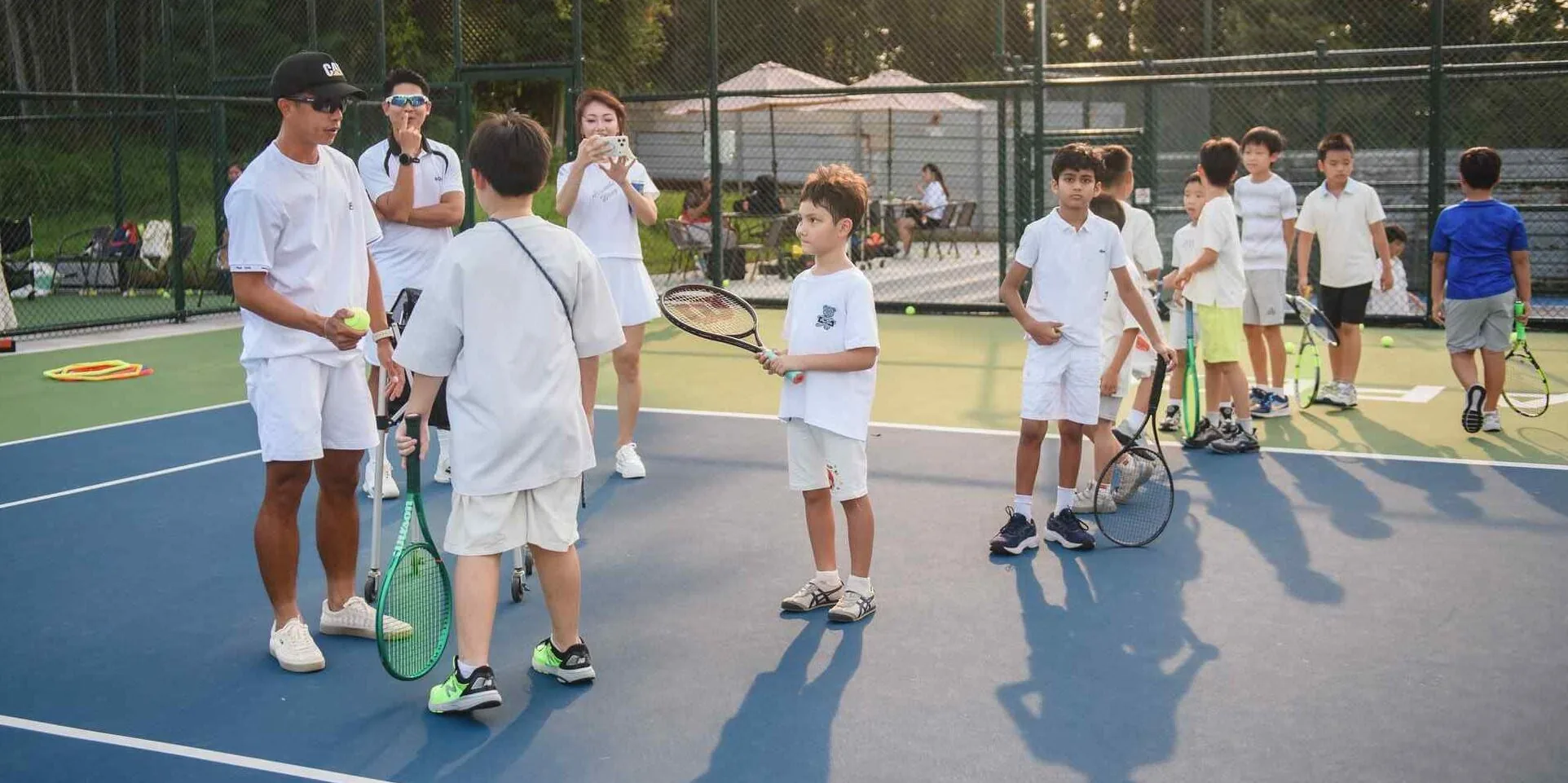 A player reaching up to serve on an outdoor court