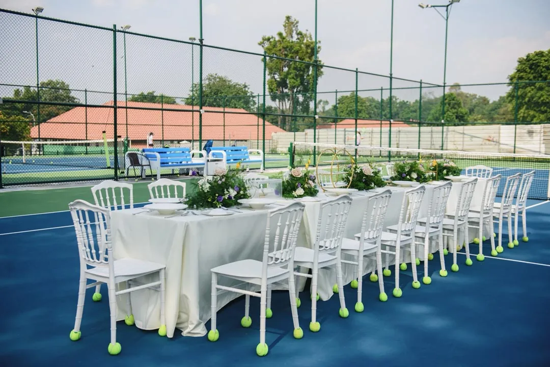 The same banquet table seen along its length, tennis balls fitted to the chair legs